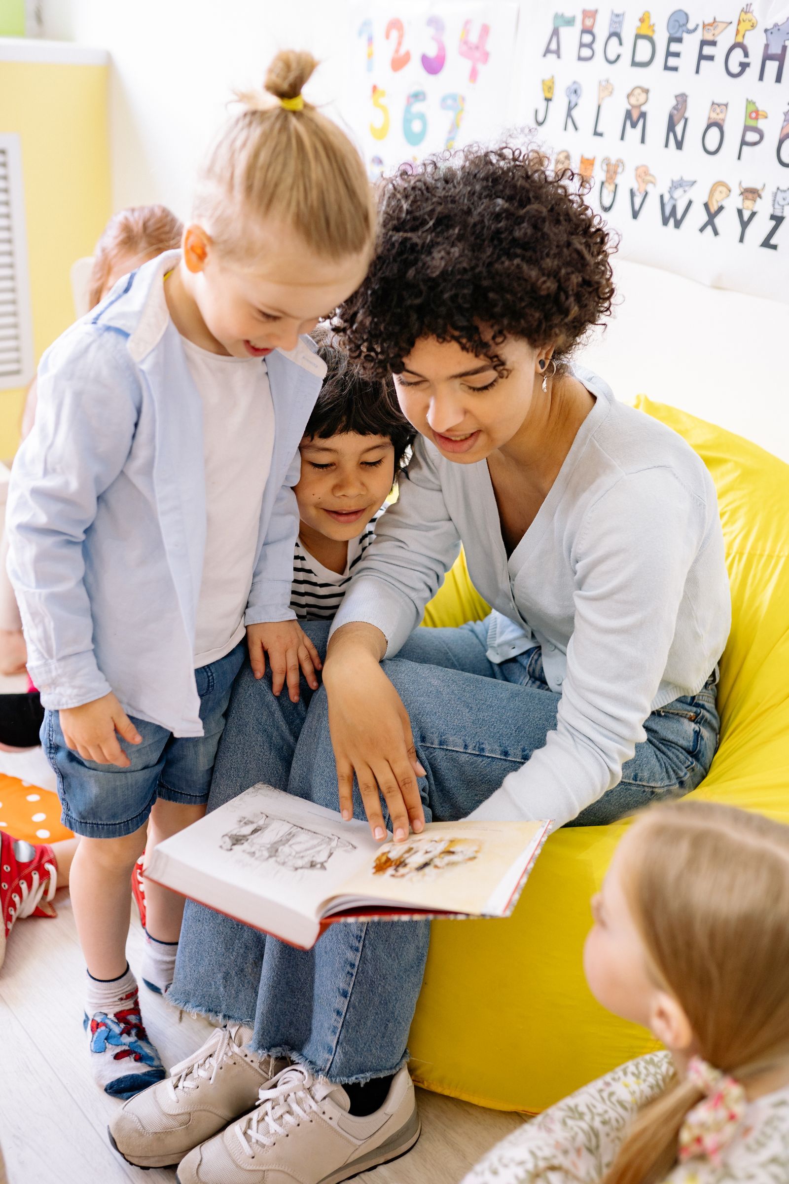 A teacher reading a book with children